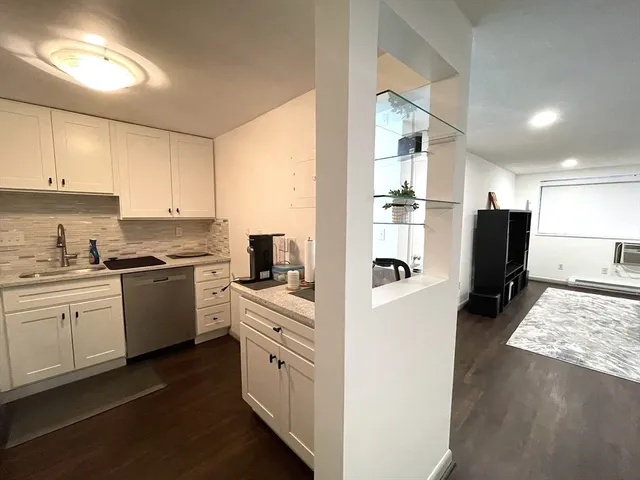 a kitchen with granite countertop a refrigerator stove top oven and sink