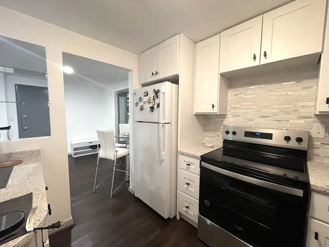 a kitchen with a refrigerator and a stove top oven