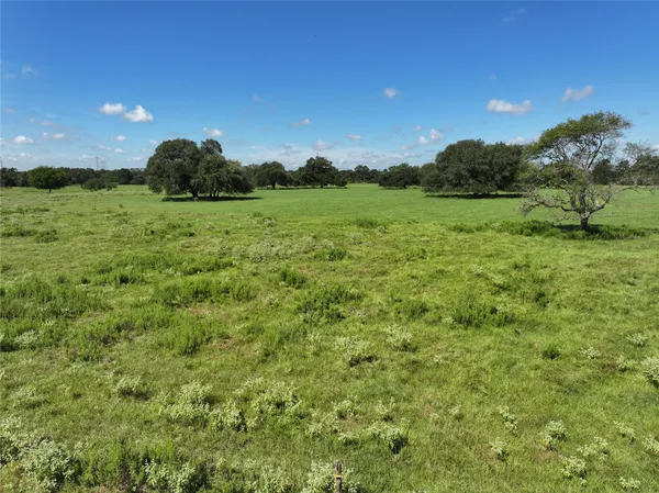 a view of a green field with wooden fence
