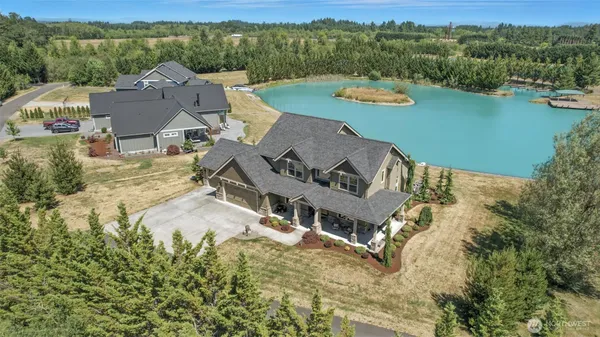 an aerial view of a house with a garden and lake view