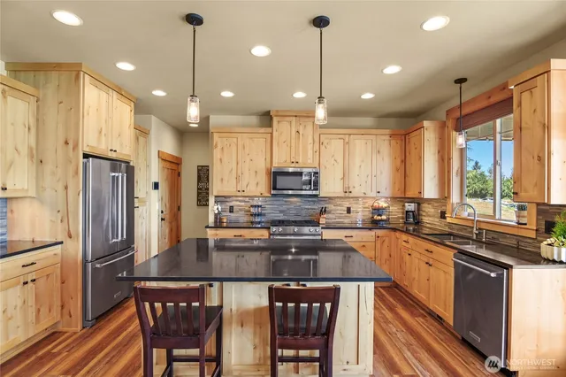 a kitchen with stainless steel appliances granite countertop counter space a sink refrigerator and cabinets