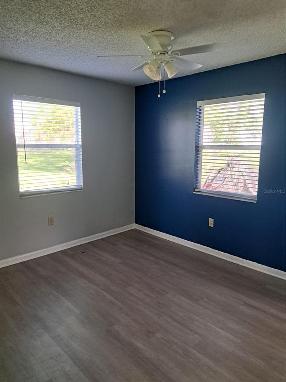 5618 Rosewall Circle Leesburg, FL 34748 - Photo 4 of 29 an empty room with wooden floor chandelier fan and windows