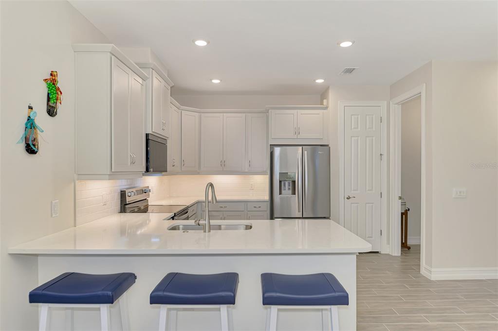 387 Ibiza Loop Venice, FL 34292 - Photo 15 of 60 a kitchen with cabinets and chairs