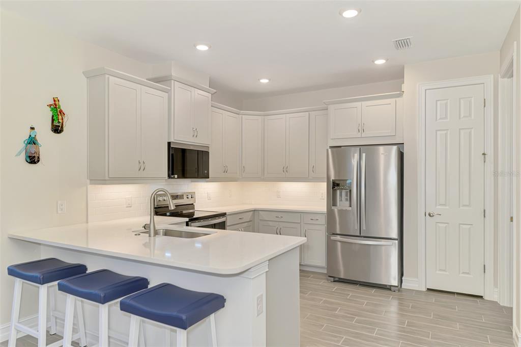 387 Ibiza Loop Venice, FL 34292 - Photo 16 of 60 a kitchen with stainless steel appliances a refrigerator sink and microwave