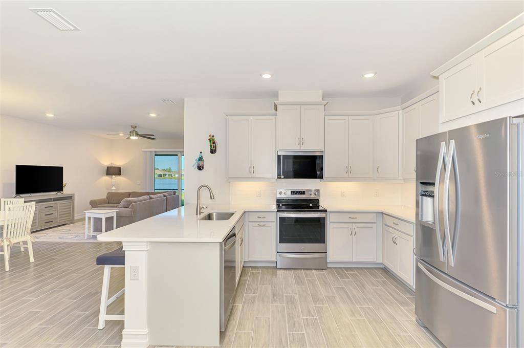 387 Ibiza Loop Venice, FL 34292 - Photo 19 of 60 a kitchen with stainless steel appliances a refrigerator stove microwave and sink