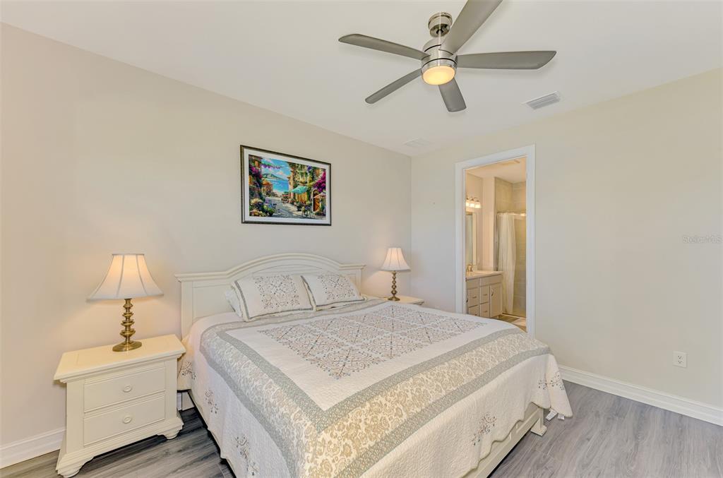 387 Ibiza Loop Venice, FL 34292 - Photo 23 of 60 a bedroom with a bed and a chandelier
