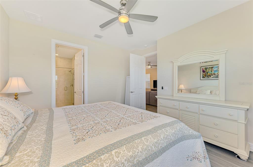 387 Ibiza Loop Venice, FL 34292 - Photo 24 of 60 a bedroom with a bed and a chandelier