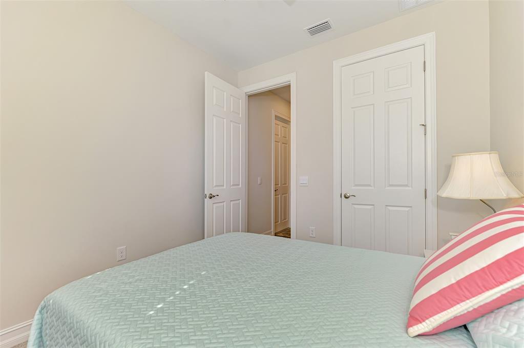 387 Ibiza Loop Venice, FL 34292 - Photo 28 of 60 a bedroom with a bed and a lamp