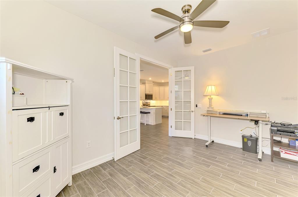 387 Ibiza Loop Venice, FL 34292 - Photo 31 of 60 a view of a kitchen with wooden floor and a ceiling fan