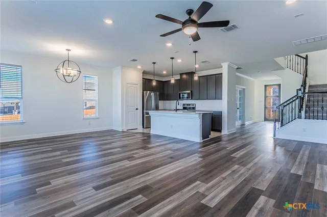 a view of a kitchen with cabinets and wooden floor