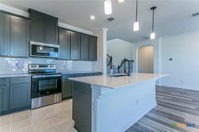 a kitchen with stainless steel appliances a sink stove and cabinets