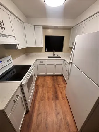 a kitchen with a microwave a sink and a refrigerator