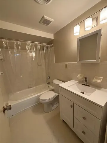 a bathroom with a double vanity sink toilet and shower