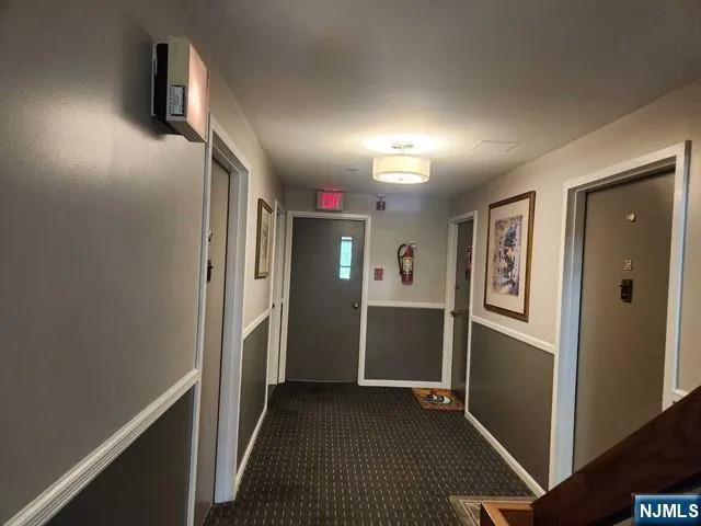 a view of hallway with stairs and wooden floor