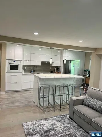 a open kitchen with stainless steel appliances granite countertop a stove a sink and a refrigerator