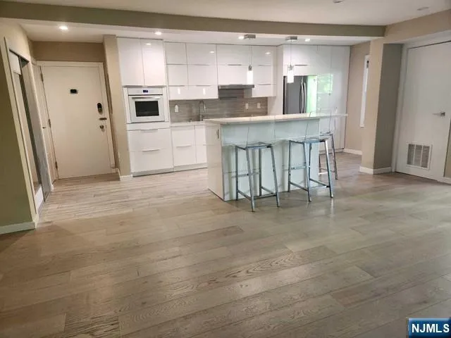 a kitchen with white cabinets and stainless steel appliances