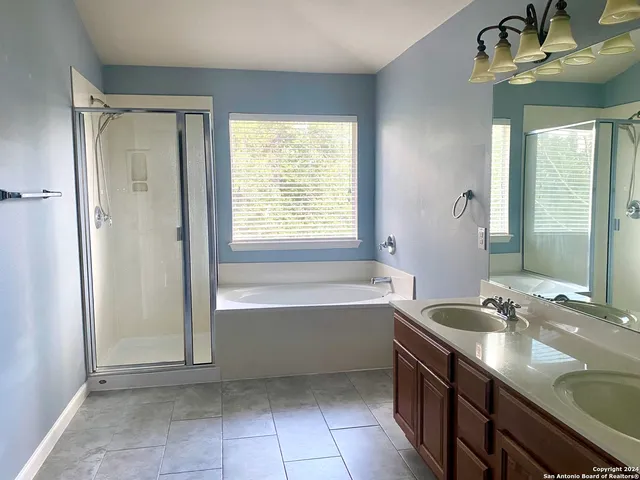 a bathroom with a tub sink and mirror