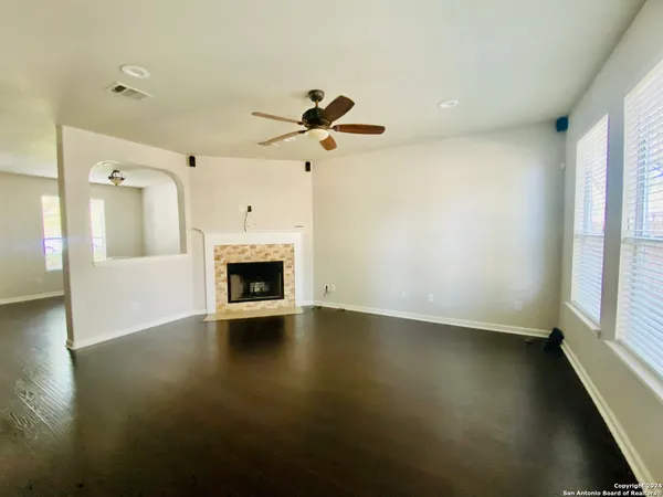 an empty room with windows and fireplace