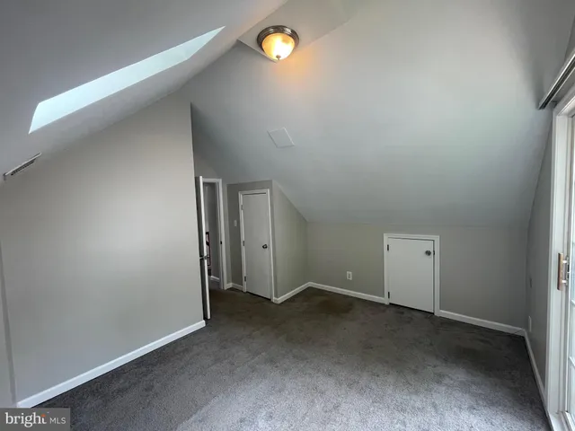 an empty room with yellow lighting and windows