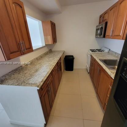 1845 Pembroke Road, Unit 322 Hollywood, FL 33020 - Photo 3 of 11 a kitchen with granite countertop a sink stove and cabinets