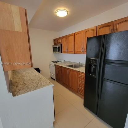 1845 Pembroke Road, Unit 322 Hollywood, FL 33020 - Photo 10 of 11 a kitchen with stainless steel appliances granite countertop a refrigerator a sink and a stove