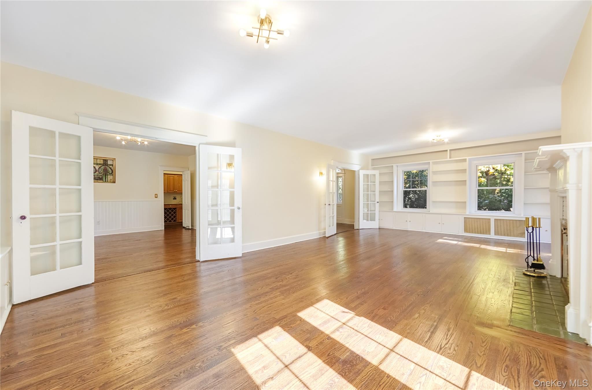 25 Whittier Road Blauvelt, NY 10913 - Photo 9 of 34 Unfurnished living room featuring french doors, built in shelves, and light wood-style floors