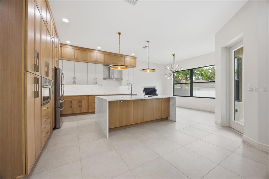 104 South Maki Road Plant City, FL 33563 - Photo 2 of 28 a large kitchen with stainless steel appliances a large counter top a refrigerator and cabinets