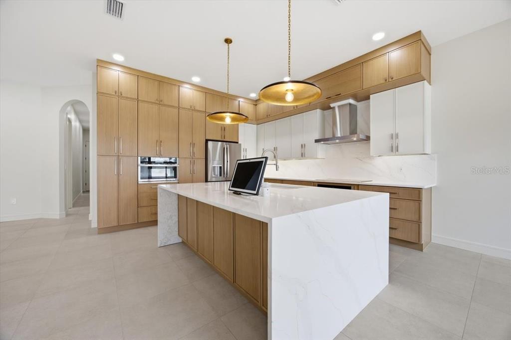 104 South Maki Road Plant City, FL 33563 - Photo 8 of 28 a kitchen with stainless steel appliances kitchen island a large island in the center
