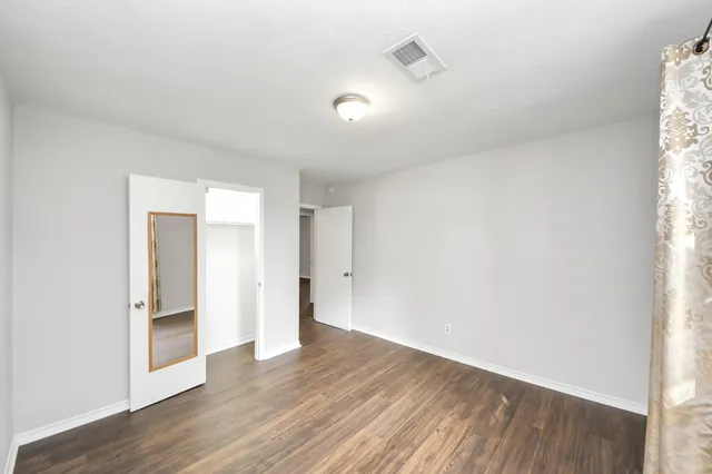 a view of wooden floor and windows in a room
