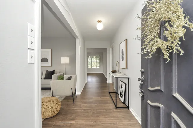 a view of a hallway with wooden floor and staircase