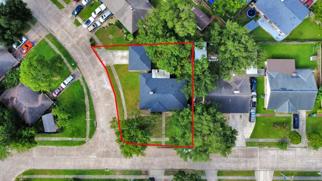 an aerial view of a house with a yard and a large pool