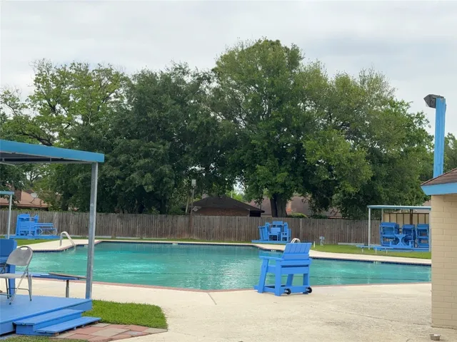 a fire hydrant in front of a tree with wooden fence