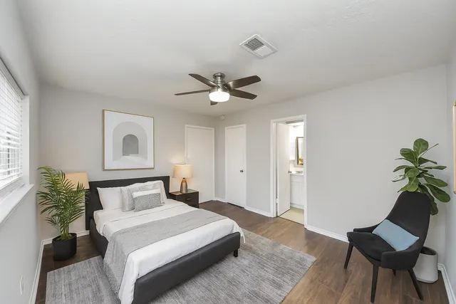 a bedroom with a bed and a potted plant