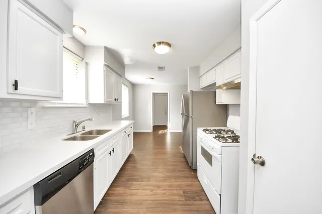 a kitchen with stainless steel appliances a sink stove and cabinets