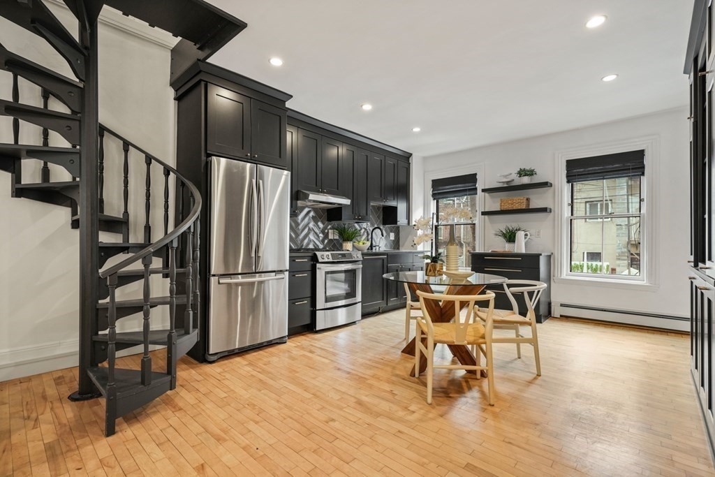 33 East Springfield Street, Unit 1 Boston, MA 02118 - Photo 6 of 31 a kitchen with stainless steel appliances kitchen island granite countertop a refrigerator a stove a sink and a dining table with wooden floor