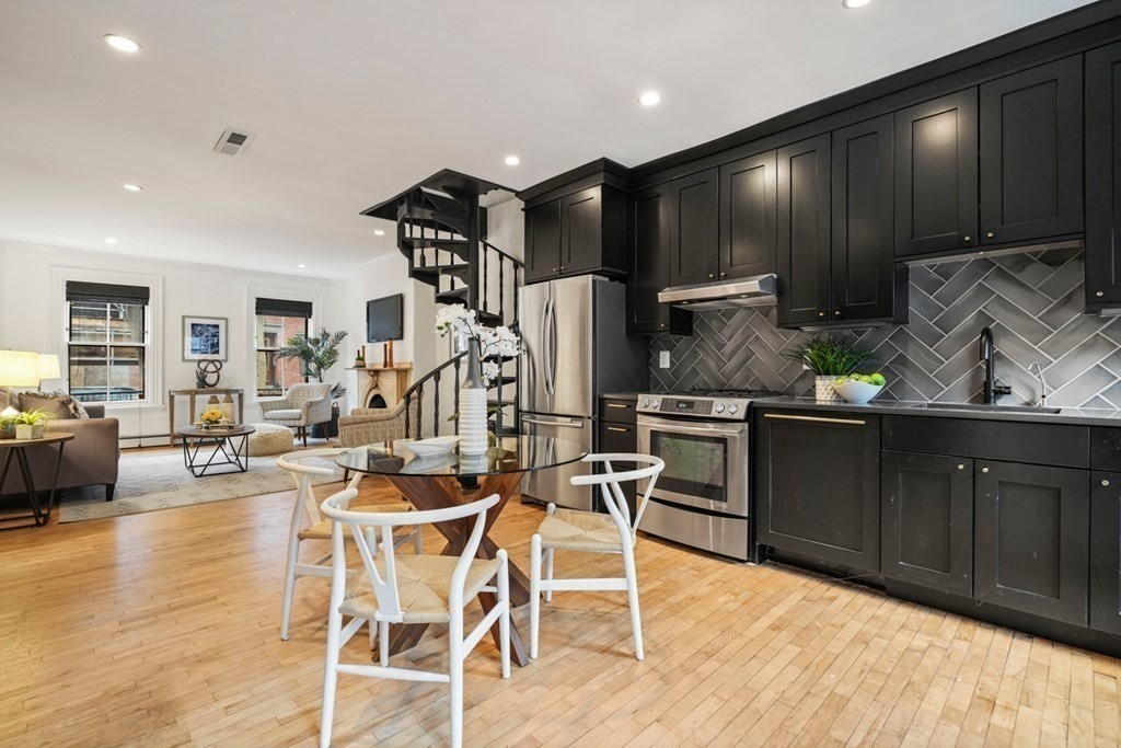 33 East Springfield Street, Unit 1 Boston, MA 02118 - Photo 9 of 31 a kitchen with stainless steel appliances kitchen island granite countertop a stove a refrigerator a sink a dining table and chairs with wooden floor