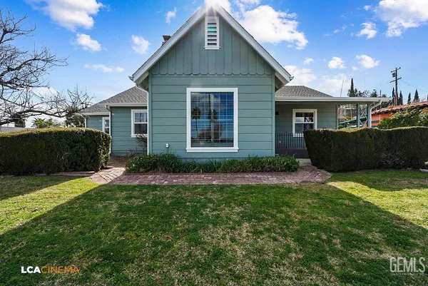 an empty room with wooden floor chandelier fan and windows
