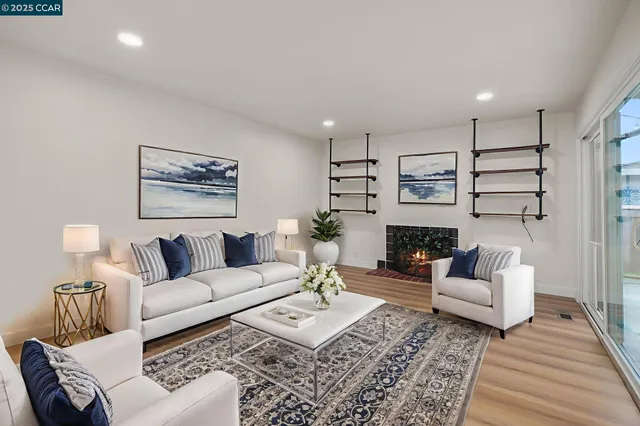 a view of empty room with wooden floor and fireplace