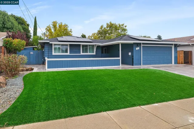 a front view of a house with a garden and yard