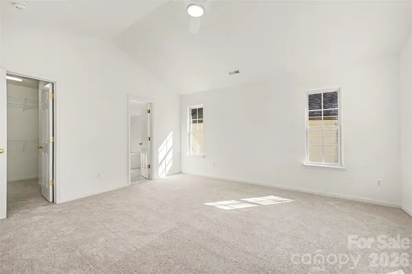 an empty room with a windows and a chandelier