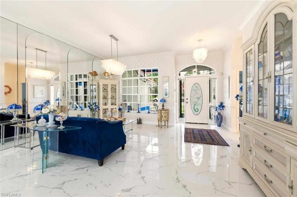 209 Countryside Drive Naples, FL 34104 - Photo 6 of 50 Entrance foyer with suspended lighting, crown molding, and light marble finish floors