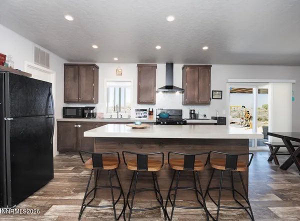 a kitchen with refrigerator a sink and chairs