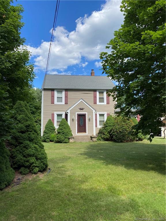 a front view of a house with yard and green space