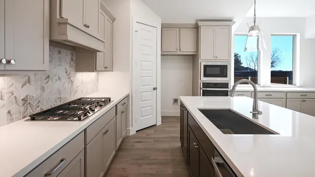 a kitchen with white cabinets and a stove top oven