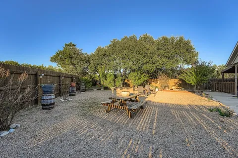 a view of a backyard with table and chairs and a large tree