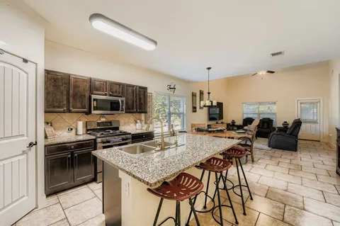 a backyard of a house with barbeque oven table and chairs