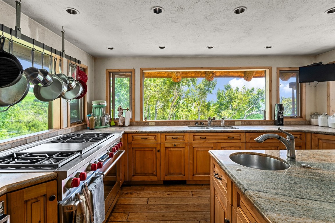 2350 Glacier Ridge Steamboat Springs, CO 80487 - Photo 16 of 47 a kitchen that has a sink a stove and a wooden floor