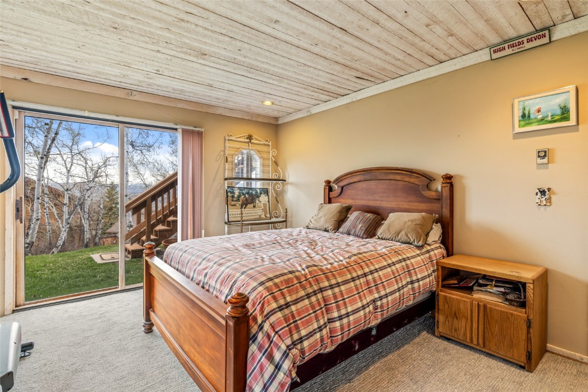 2350 Glacier Ridge Steamboat Springs, CO 80487 - Photo 31 of 47 a bedroom with a bed dresser and a large window