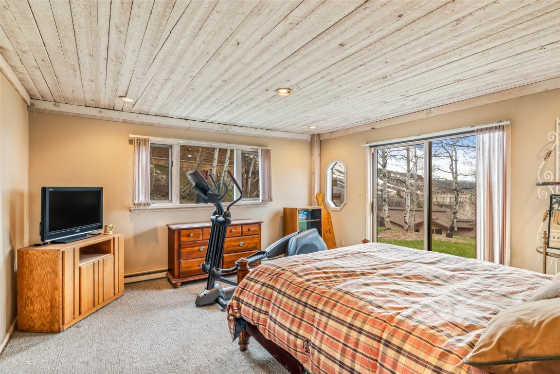 2350 Glacier Ridge Steamboat Springs, CO 80487 - Photo 32 of 47 a bedroom with a bed and large windows