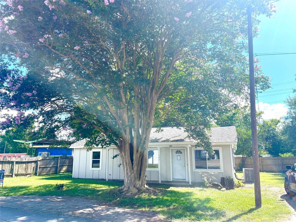 104 Peach Street Tomball, TX 77375 - Photo 17 of 19 a front view of a house with a yard and green space